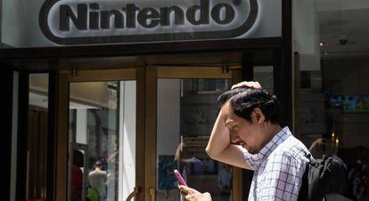 Un home juga al Pokémon Go al costat d'una botiga de Nintendo a Nova York