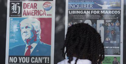 Una mujer observa las portadas de los periódicos con la victoria de Trump.