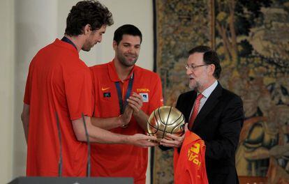 Gasol, a la izquierda, regala al presidente del Gobierno, Mariano Rajoy, un balón de plata en La Moncloa tras la victoria en el Eurobasket.