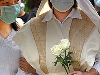 La viuda de un enfermero muerto por la neumonía en Hong Kong, en el entierro del marido.
/ AP