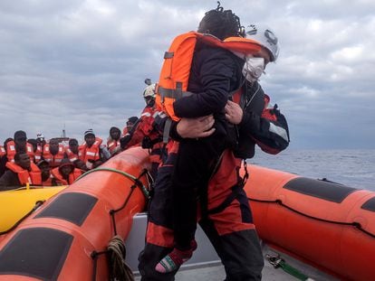 Un miembro del equipo del 'Sea-Watch 3' ayuda a abordar a un niño durante una operación de rescate en el Mediterráneo el 26 de febrero.