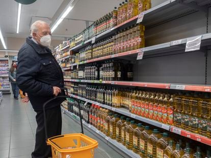Un hombre, frente a los lineales de aceite de un supermercado de Barcelona.