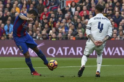 Luis Suárez del FC Barcelona lanza el esférico ante Sergio Ramos.