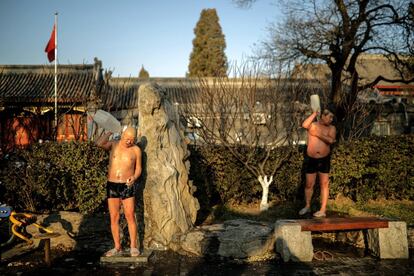 Nadadores se lavan el cuerpo después de nadar en el lago Houhai, medio congelado, en la ciudad de Pekín (China).