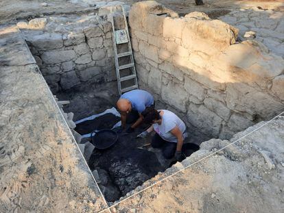 Dos arqueólogos excavan una habitación subterránea del edificio romano de Nueva Carteya.