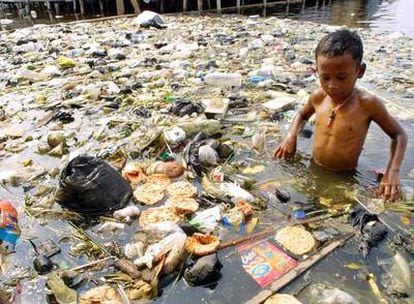 Un niño indonesio juega en una balsa de agua llena de basura en Muara Baru, al norte de Yakarta.