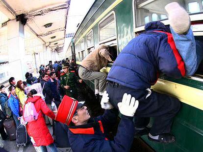 Pasajeros tratan de asegurarse un asiento en un tren en la estación de Wuxi, en el este de China.