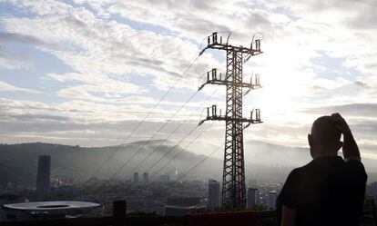 Una persona observa el cableado con el que la red eléctrica transporta energía sobre la ciudad de Bilbao.