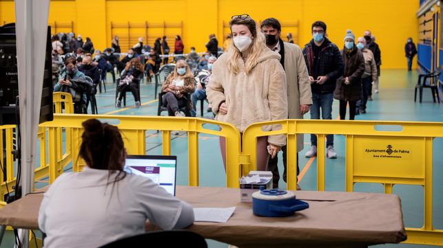 GRAF2763. PALMA DE MALLORCA, 28/12/2020.- Varias personas esperan su turno para las pruebas de coronavirus en el cribado poblacional organizado por la Conselleria de Salud en el barrio del Rafal Nou de Palma de Mallorca en el polideportivo Germans Escales este lunes. EFE/ Atienza