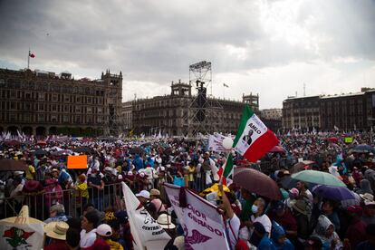 Partidarios de López Obrador se protegen con sombrillas y capasplásticas de la lluvia.