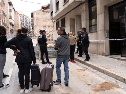 Vecinos de los edificios colindantes al edificio de cinco plantas (tres en altura más dos sótanos) ubicado en el número 21 de la calle San Francisco de Teruel, que ayer se derrumbó tras ser desalojado momentos antes, recogen enseres personales.