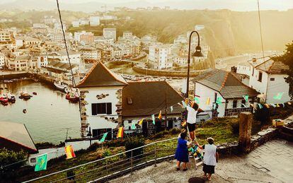 Fiestas de Luarca (Asturias).
En la imagen de Gianfranco Tripodo, fotógrafo filipino afincado en Madrid, un pequeño grupo de vecinas engalanan este pueblo colocando banderines. Y es que el Principado de Asturias en verano es una fiesta. Luarca, ubicada en el concejo de Valdés, es una villa marinera que dobla su población durante los meses estivales. Pero es el 22 de agosto cuando se celebra San Timoteo y las calles son un hervidero de gente. Gaiteros, charangas, gigantes y cabezudos se dan cita en la ermita para sacar al santo en procesión. Los romeros, ataviados con chambón de cuadros azules y blancos, bastón de madera y la T de pan al cuello, corean al unísono: “San Timoteo, eo, eo, eo”. Una vez terminada la misa, tiene lugar la comida campestre y la verbena continúa hasta que el cuerpo aguante.