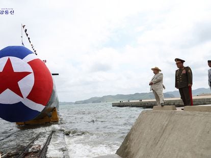 El líder norcoreano, Kim Jong-un (a la izquierda, con sombrero) supervisa la puesta a flote de un nuevo submarino con capacidad nuclear, en el astillero de Sinpho, el miércoles.