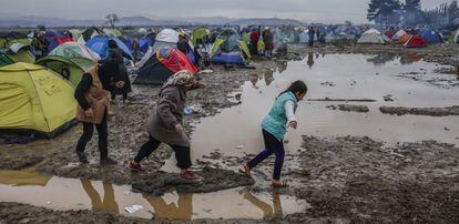 Refugiados caminan por el barro en un campamento cercano a Idomeni, en la frontera entre Grecia y Macedonia.