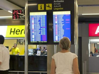 Una persona comprueba el estado de un vuelo en una pantalla del aeropuerto de Palma de Mallorca, en una jornada de huelga de controladores a&eacute;reos.