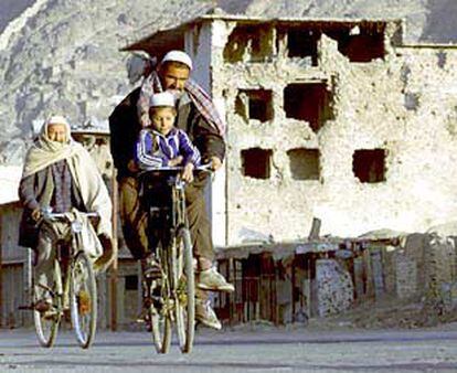Vecinos de Kabul se desplazan en bicicleta por un barrio destruido en las sucesivas guerras.