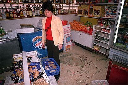 La viuda del comerciante chino observa la sangre y los destrozos registrados en el local durante el atraco.