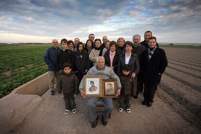 Matías Gimeno Orts, rodeado por familiares de Juan Bautista García Sales, sostiene la foto de la víctima a la derecha y la suya, a la izquierda.