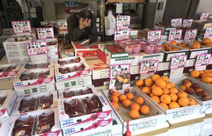 Un frutero espera a su casi inexistente clientela en un mercado de Tokio.