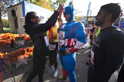 Un corredor vestido como el Capitán América recibe la medalla tras cruzar la línea de meta en el maratón de Nueva York, 3 de noviembre de 2013.