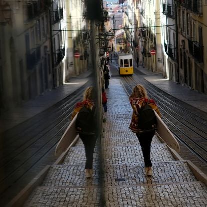 Una mujer transporta una tabla de surf por el centro de Lisboa el pasado 5 de noviembre.