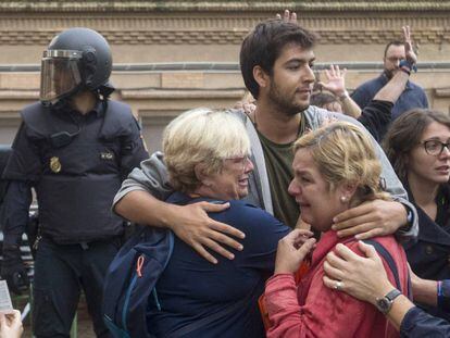 Varias personas lloran en el exterior del Instituto Can Vilumara de L'Hospitalet de Llobregat ante el despliegue policial.