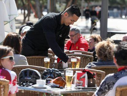 Un camarero atiende a los clientes en una de las terrazas de los bares en las calles de Madrid. 