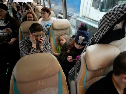 Una mujer y su hija usan sus móviles en un autobús que la traslada de Ucrania a Przemysl, Polonia, el jueves.