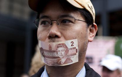 Una instantánea de la manifestaciones que se ha desarrollado en las calles de Toronto. Un hombre se tapa la boca con un billete.