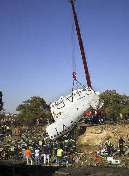 Una grúa levanta el pasado jueves lo poco que quedó del avión siniestrado en el aeropuerto de Barajas.