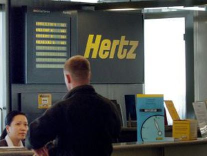 Un hombre permanece en un mostrador del servicio de alquiler de veh&iacute;culos Hertz. 