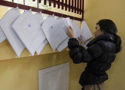 Una ciudadana consultan en las listas de un colegio electoral de Madrid.