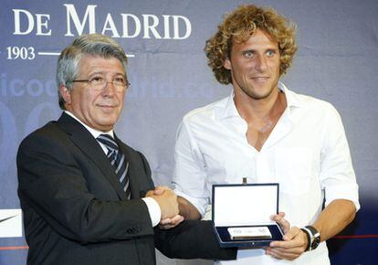 El presidente del Atlético, Enrique Cerezo, le entrega una placa de recuerdo a Diego Forlán.