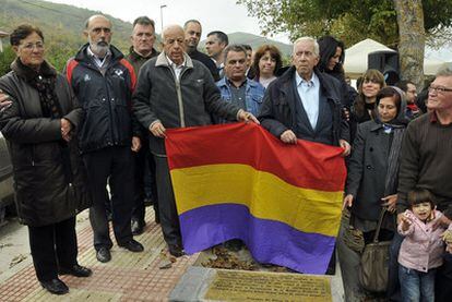 Los hijos de Emilio Silva Faba sostienen una bandera republicana durante el acto de ayer.