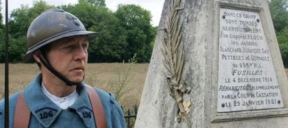 Un miembro de una asociación de memoria de la I Guerra Mundial vestido de 'poilu' junto a un monumento en homenaje a varios soldados fusilados.