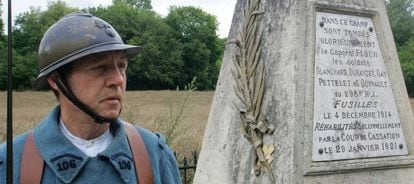 Un miembro de una asociaci&oacute;n de memoria de la I Guerra Mundial vestido de &#039;poilu&#039; junto a un monumento en homenaje a varios soldados fusilados.