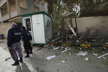 Dos polic&iacute;as junto al lugar donde explotaron los artefactos en la puerta de la residencia del embajador iran&iacute; en Tr&iacute;poli. 