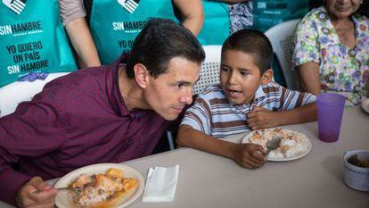 El presidente de México, Enrique Peña Nieto, habla con un niño durante una gira de trabajo en Michoacán realizada este martes.