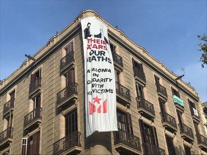 Pancarta en anglès penjada en un edifici de la Rambla amb un dibuix que emula una fotografia de Felip VI i el rei de l'Aràbia Saudí per denunciar la vinculació de la monarquia amb el comerç d'armes.