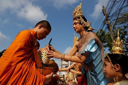 En la celebración, tradición y fiesta van de la mano. Con los primeros rayos de sol de cada 13 de abril, los budistas más devotos se acercan a los templos para recitar oraciones y realizar ofrendas a los monjes para conseguir buena suerte para el año entrante. En la imagen, una mujer vestida con el traje tradicional de Tailandia da una ofrenda a un monje budista en Bangkok.