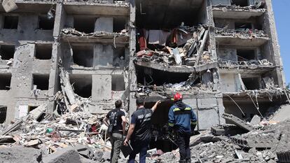 Personal de los servicios de rescate junto a uno de los edificios alcanzados por un bombardeo ruso, este viernes en la localidad de Serhiivka.