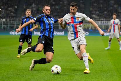 Robert Lewandowski fights for the ball with Stefan de Vrij in the duel between Inter and Barcelona.