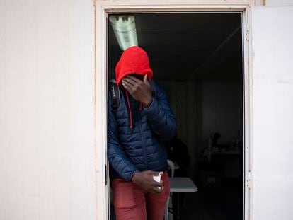 Bacary Camará, 35 años, procedente de Senegal se tapa la cara en la puerta de la cafetería habilitada en el exterior del albergue temporal instalado por el Ayuntamiento de Níjar (Almería) tras el desalojo del campamento el Walili.