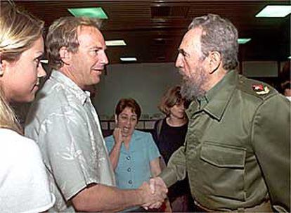 Kevin Costner y Fidel Castro se saludan ayer en presencia de Christine Baumgartner, novia del actor.