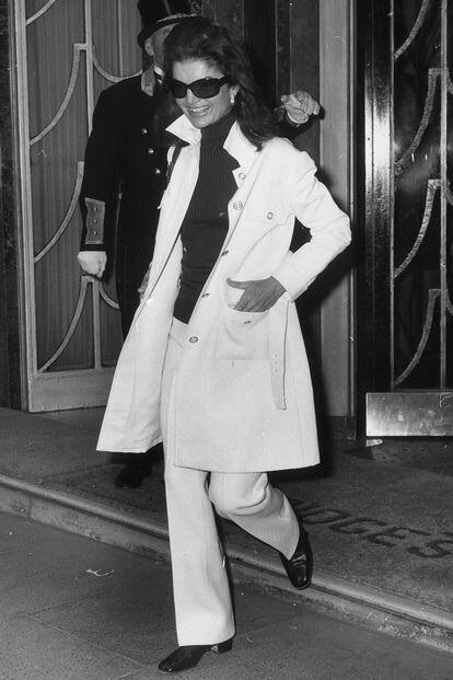 Gabardina blanca y pantalón a juego combinados con jersey negro de cuello alto. La que fuera esposa de John F. Kennedy hasta su asesinato en 1963 era experta en hacer complejo y perfecto lo más simple. Las gafas de sol grandes la acompañaban a todas partes.