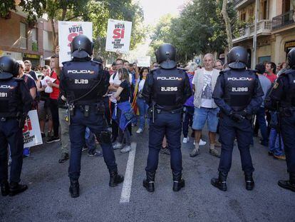 Policías y manifestantes ante la sede de la CUP, el 20 de septiembre de 2017. En vídeo, altercados en la Consejería de Economía el 20 de septiembre.