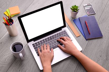 Woman hand using blank screen laptop computer on an office desk.