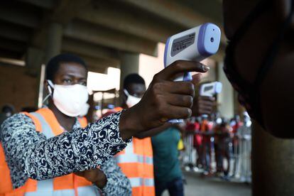 Se toma la temperatura de un comerciante a la entrada del mercado central de Rood-Wooko, en Ouagadougou, Burkina Faso.