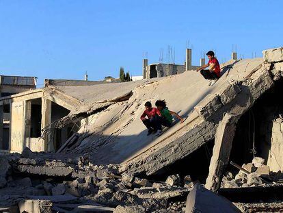 Unos niños se deslizan sobre uno de los edificios destruidos en Daraya, cerca de Damasco.