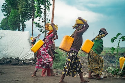 Mujeres desplazadas cargan bidones de agua después de caminar 10 kilómetros para llenarlos, debido a la falta de agua en el campo de desplazados de Bulengo, cerca de Goma, en el este de la República Democrática del Congo, asolada por la violencia.